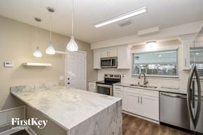 Jacksonville house for rent - a kitchen with marble counter tops and stainless steel appliances
