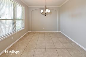 Baytown house for rent - an empty dining room with a large window and a chandelier