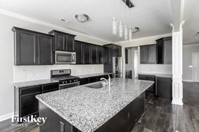 Statesville house for rent - A kitchen with a granite countertop and black cabinets.