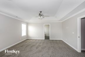 Statesville house for rent - A spacious room with a ceiling fan and carpeted floor.