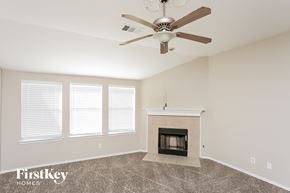 Fort Worth house for rent - A room with a fireplace and a ceiling fan.