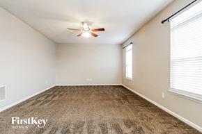 Indianapolis house for rent - A room with a carpeted floor and a ceiling fan.