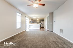 Indianapolis house for rent - A spacious room with a carpeted floor and a ceiling fan.