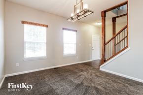 Indianapolis house for rent - A spacious room with a staircase leading to another room.