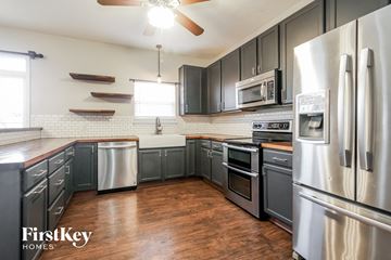 Indianapolis house for rent - A kitchen with wooden floors and stainless steel appliances.