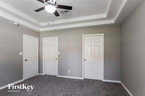 Conroe house for rent - a bedroom with two doors and a ceiling fan