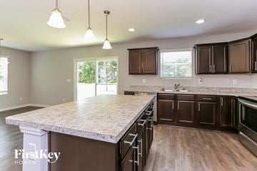 Jacksonville house for rent - a kitchen with a large island and dark wood cabinets