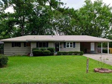 Jackson house for rent - A house with a brown roof and a green lawn.