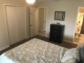 Palmetto house for rent - a bedroom with a bed and a dresser and a bathroom