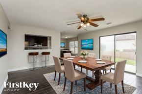 San Antonio house for rent - A dining room with a wooden table and chairs, a ceiling fan, and a painting on the wall.