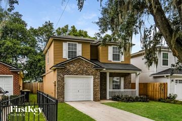 Jacksonville house for rent - a yellow house with a white garage door