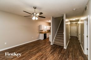 Jacksonville house for rent - a living room with a staircase and a ceiling fan