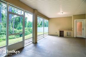 St. Johns house for rent - A large empty room with a view of trees outside through the windows.