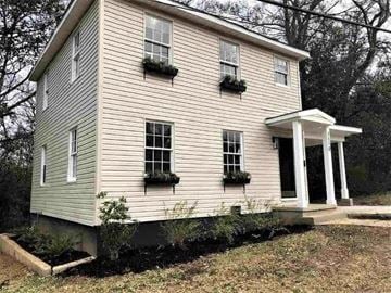 Jackson house for rent - A two-story house with a porch and flower boxes on the windows.