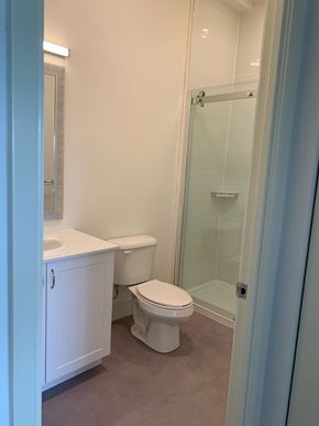 Belleville apartment for rent - A white toilet sits in a bathroom next to a walk-in shower.
