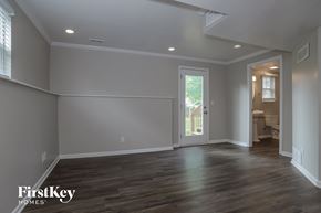 Raymore house for rent - a living room with grey walls and a door to a bathroom