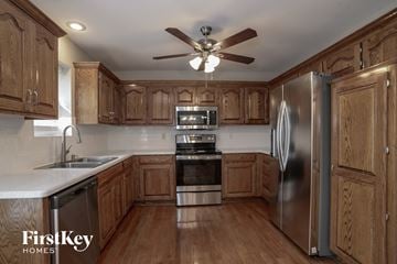 Raymore house for rent - a kitchen with wooden cabinets and stainless steel appliances