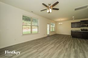 Winston Salem house for rent - A spacious room with a ceiling fan and wooden flooring.