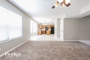 Indianapolis house for rent - A spacious room with a carpeted floor and a ceiling fan.