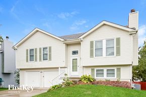 Kansas City house for rent - A two-story house with a white garage door and a brick wall.