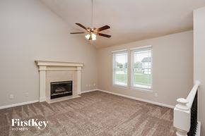 Kansas City house for rent - A room with a fireplace and a ceiling fan.