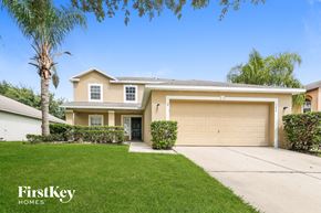 Groveland house for rent - a beige house with a garage door and a lawn