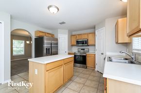 Groveland house for rent - a kitchen with wooden cabinets and stainless steel appliances