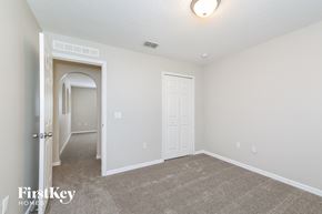 Groveland house for rent - a bedroom with a carpeted floor and a door to a hallway