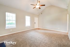 Covington house for rent - an empty living room with a ceiling fan and a window