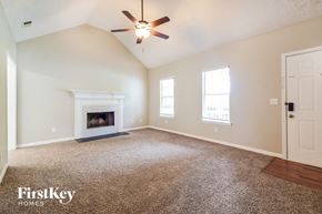Covington house for rent - an empty living room with a fireplace and a ceiling fan