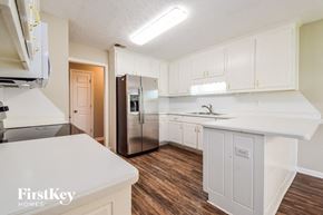 Covington house for rent - a kitchen with white cabinets and a stainless steel refrigerator