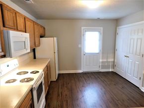 Jacksonville house for rent - A kitchen with white appliances and wooden cabinets.