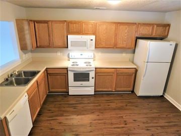 Jacksonville house for rent - A kitchen with wooden cabinets and white appliances.