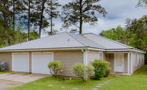 Brandon apartment for rent - a small white house with two garage doors and a porch