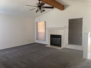 Killeen house for rent - A room with a fireplace and a ceiling fan.