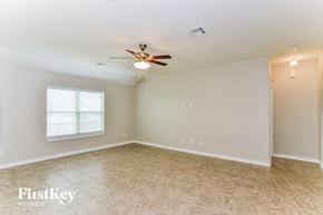 Converse house for rent - A spacious room with a ceiling fan and a window with blinds.