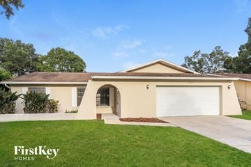Largo house for rent - a beige house with a garage door and a lawn