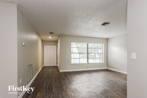 Largo house for rent - the living room of an empty house with wood flooring and a large window