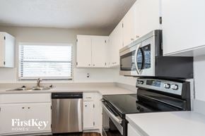 Largo house for rent - a kitchen with white cabinets and stainless steel appliances and a sink