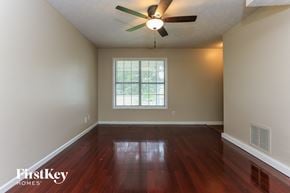 Loganville house for rent - the living room with hardwood floors and a ceiling fan