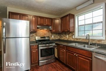 Loganville house for rent - a kitchen with stainless steel appliances and wooden cabinets