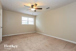 Loganville house for rent - a bedroom with carpet and a ceiling fan