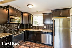 Clarksville house for rent - a kitchen with stainless steel appliances and black cabinets