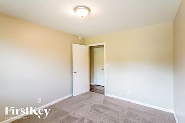 Clarksville house for rent - a living room with carpet and a door to a hallway