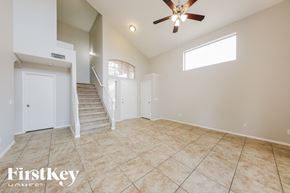 Peoria house for rent - A spacious room with a staircase and a ceiling fan.