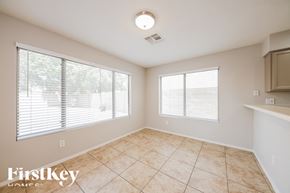 Peoria house for rent - A room with a tiled floor and two windows covered with blinds.