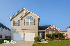 Pendergrass house for rent - a tan house with a white garage door and a red brick house