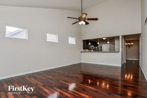 St Charles house for rent - an empty living room with wood floors and a ceiling fan