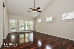 St Charles house for rent - an empty living room with wood floors and a ceiling fan