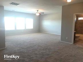 Weatherford house for rent - A spacious room with a carpeted floor and a ceiling fan.
